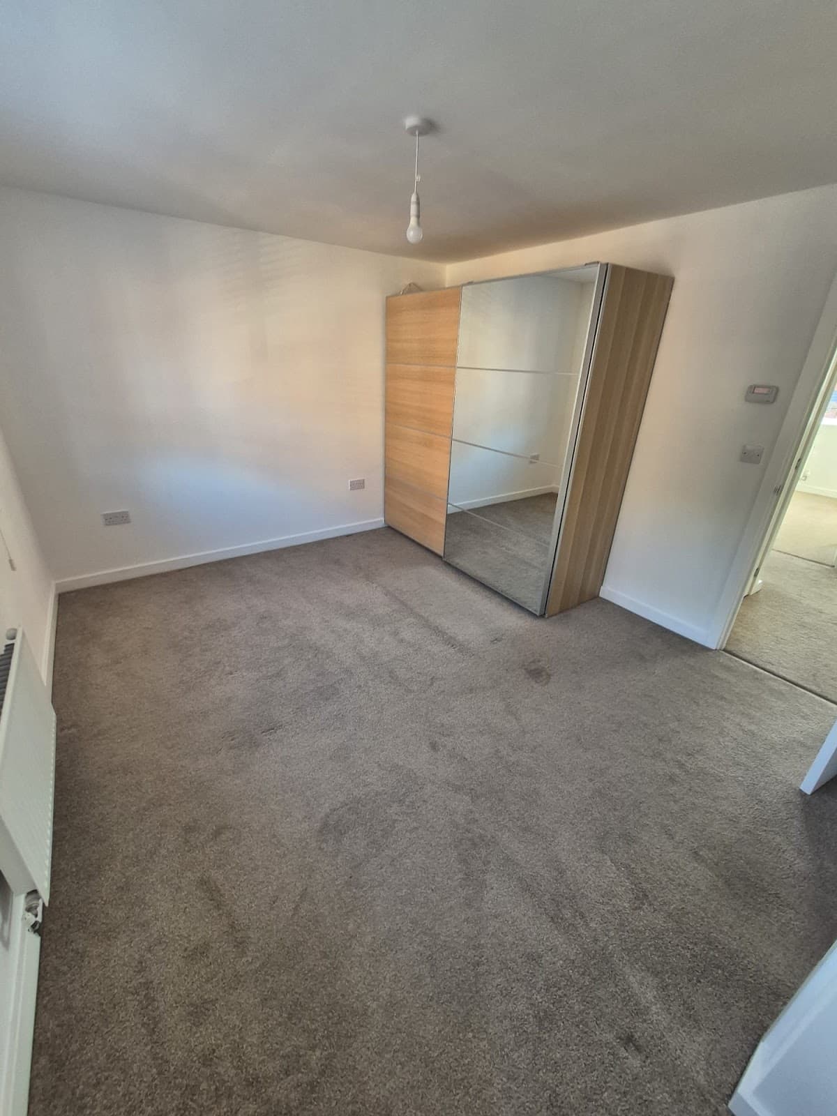 After — Full property renovation at 30 Thistle Way, Lincoln — freshly decorated bedroom with new carpet and fitted wardrobe