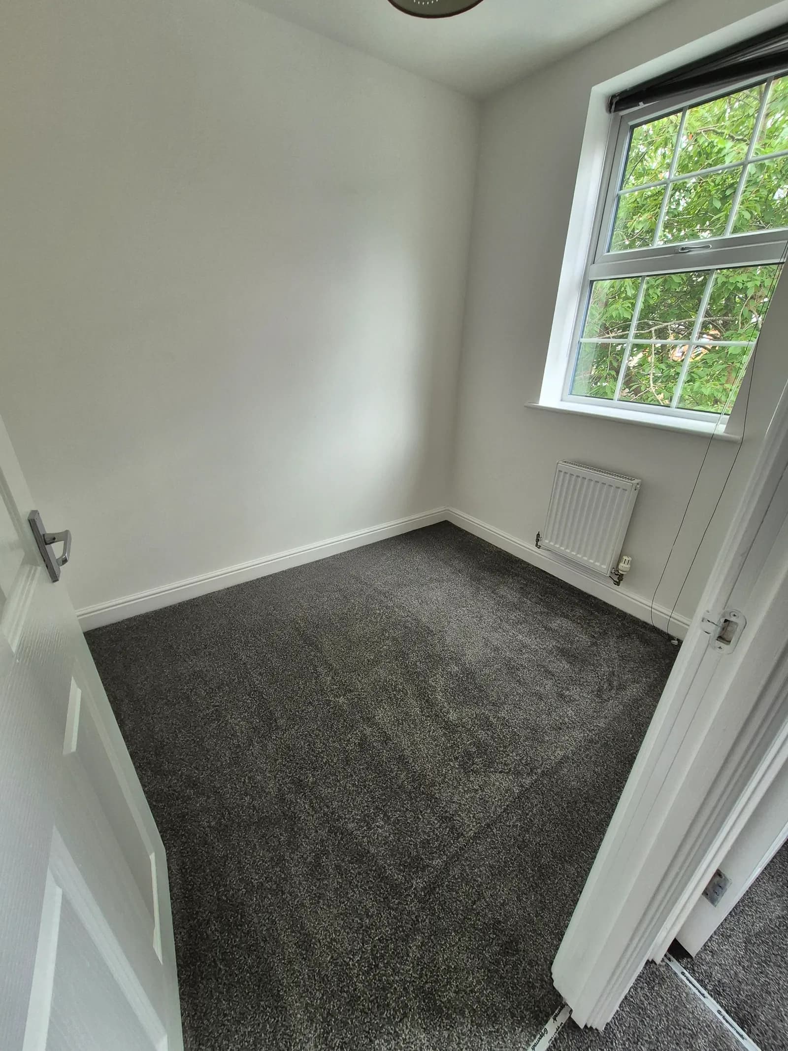 Freshly fitted dark grey carpet in a Lincoln rental bedroom, an LWR Group supply-and-fit job