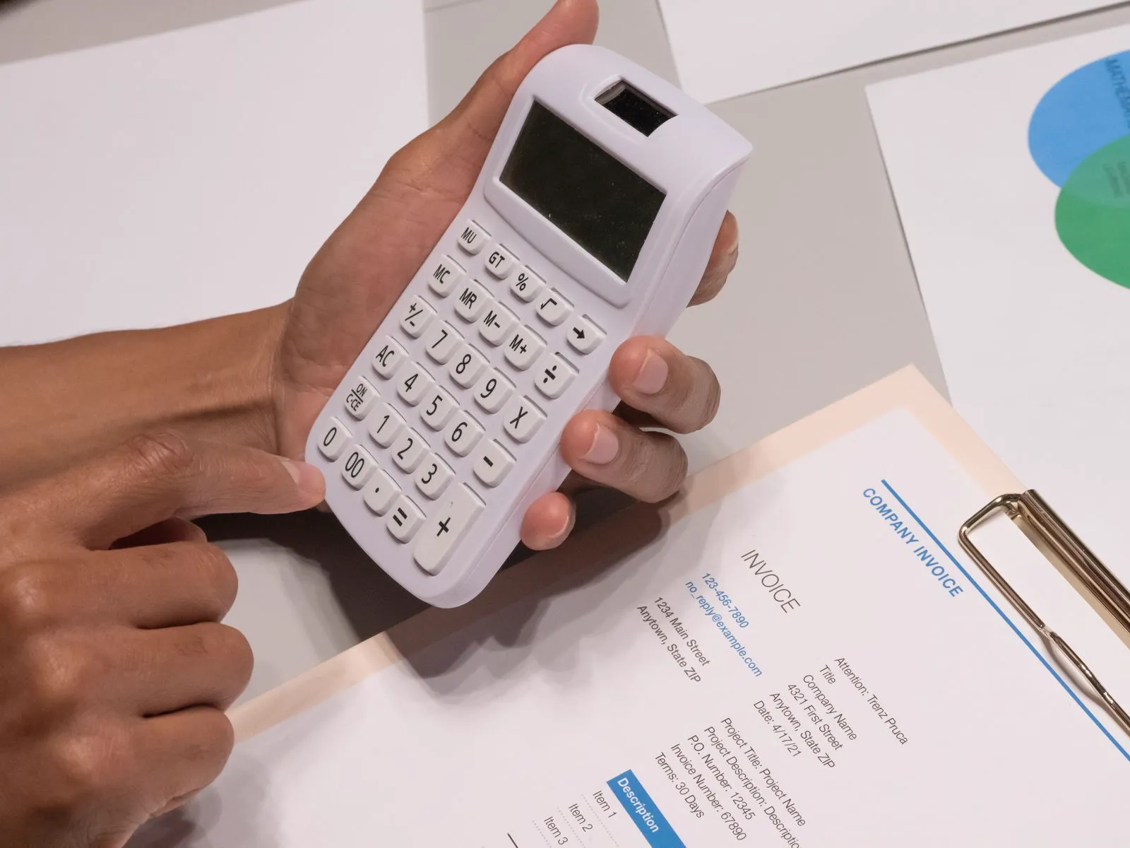 A calculator and invoice on a desk, working out the cost of commercial and office cleaning in 2026