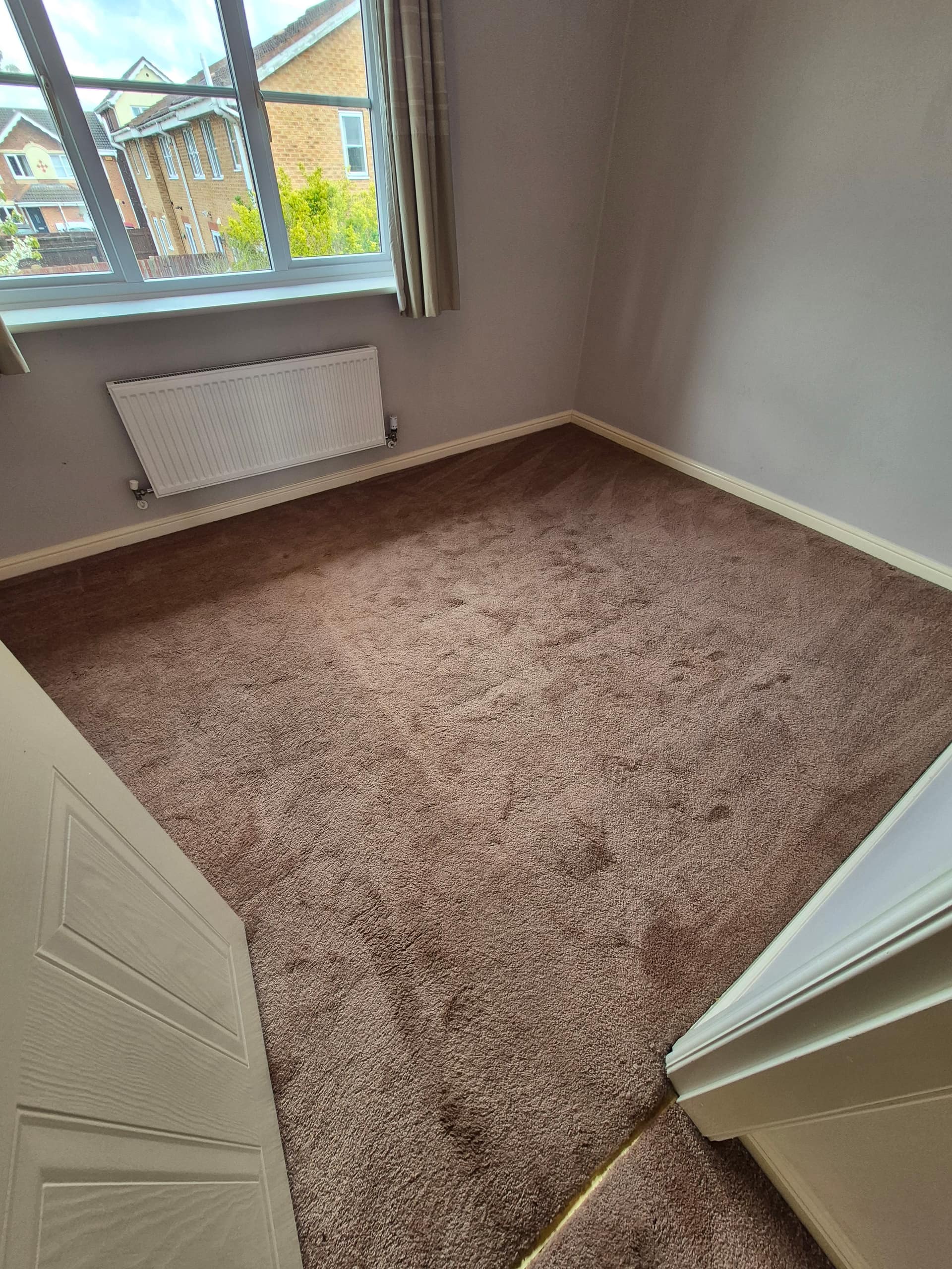 Professionally cleaned brown carpet in a Lincoln rental property bedroom by LWR Group, showing clean even result throughout the room
