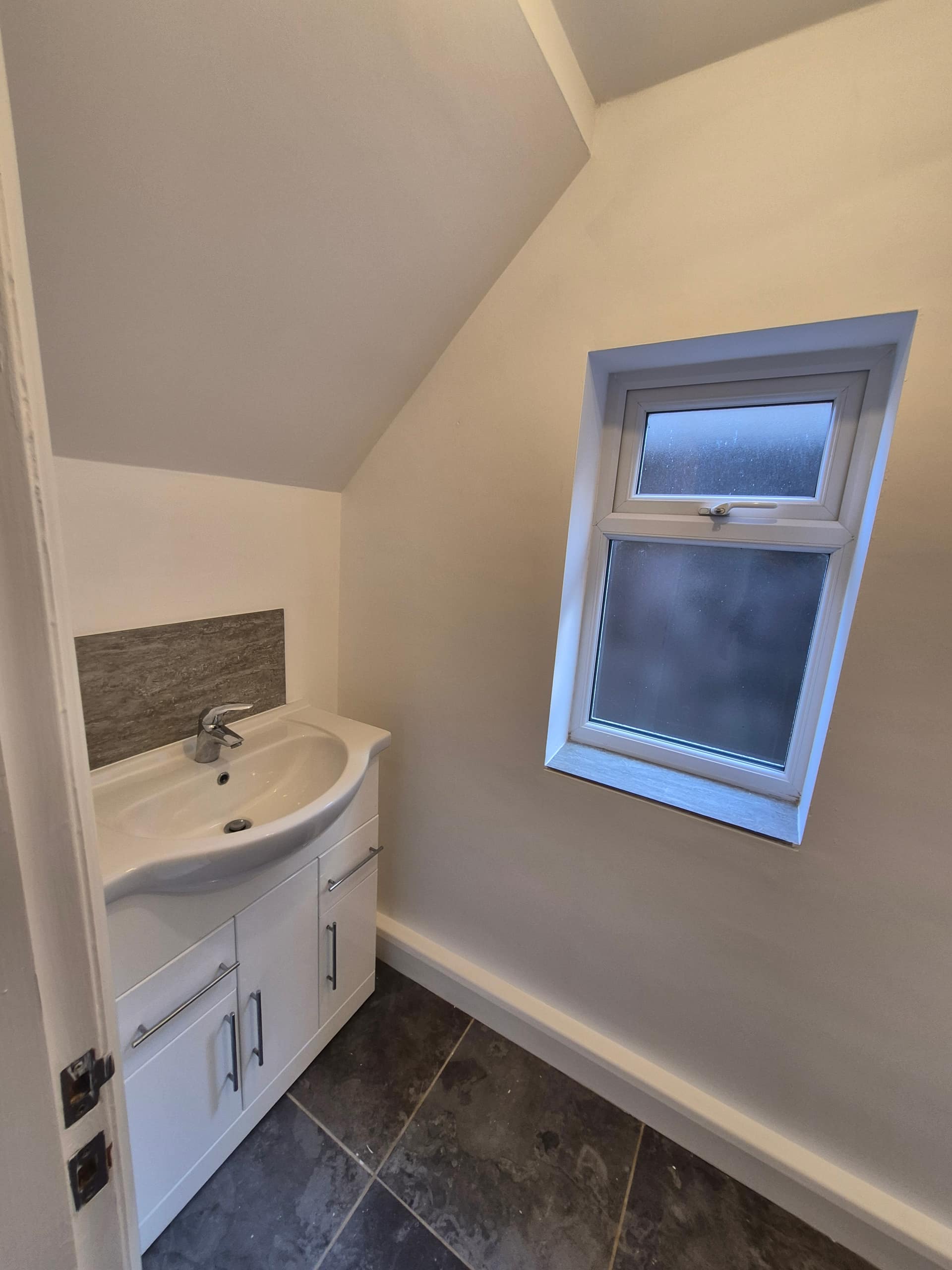 Freshly decorated bathroom in a Lincoln rental property completed by LWR Group, with clean white walls, vanity unit and new window reveal