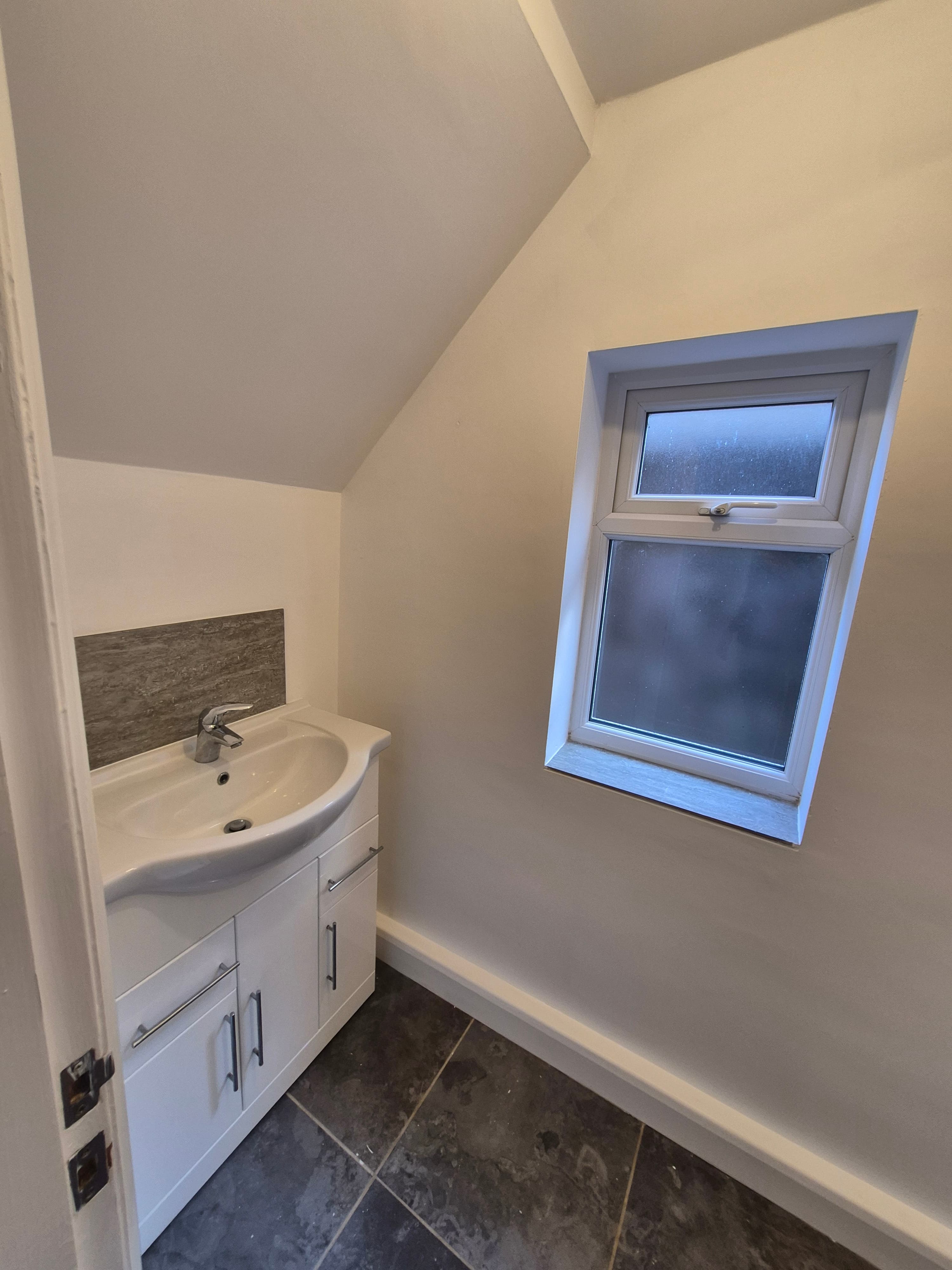 Freshly decorated bathroom in a Lincoln rental property completed by LWR Group, with clean white walls, vanity unit and new window reveal