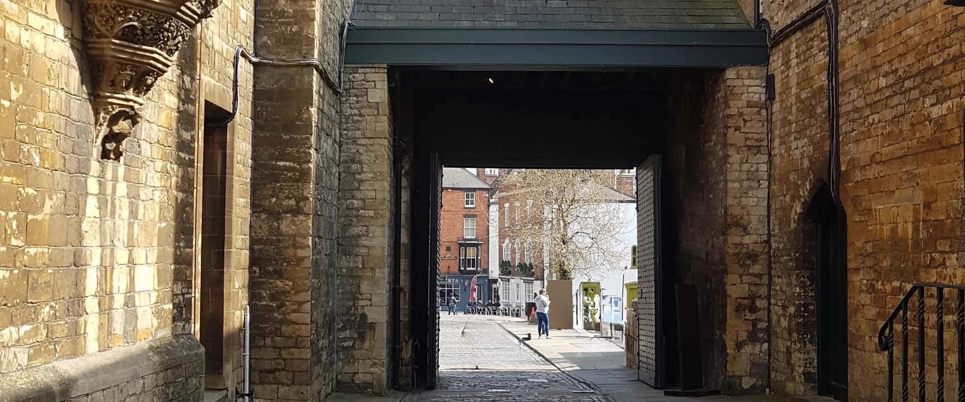 Historic stone archway on a cobblestone street in Lincoln's old town
