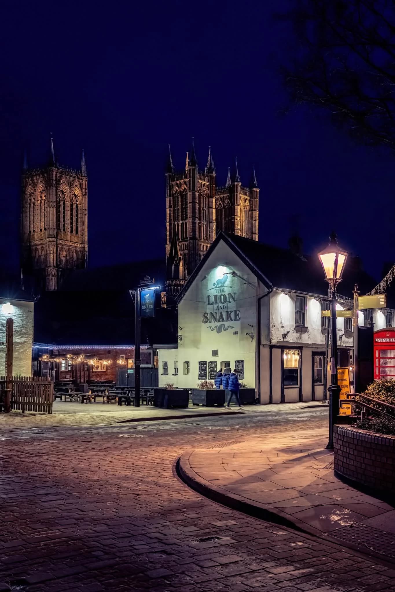 Lincoln Cathedral lit up at night above The Lion and Snake pub on Bailgate, an iconic view of historic Lincoln city centre
