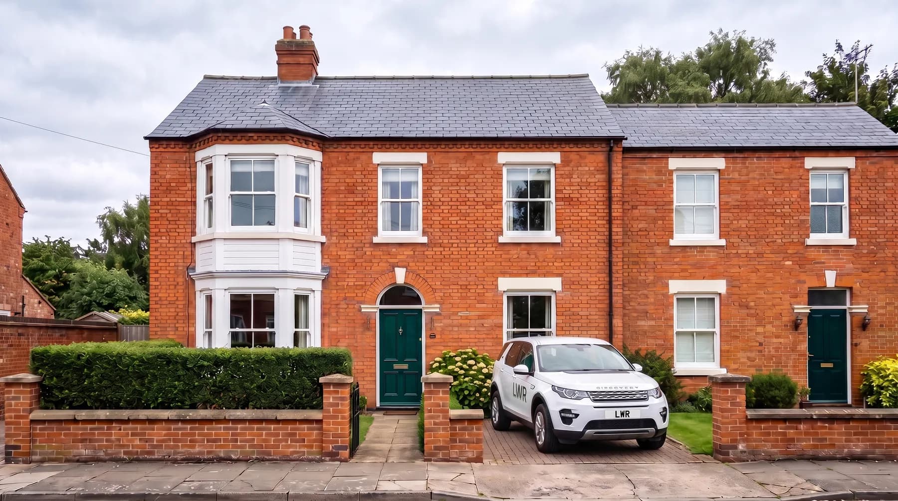 Front of a red-brick Victorian semi-detached house in Lincoln with the LWR vehicle on the driveway