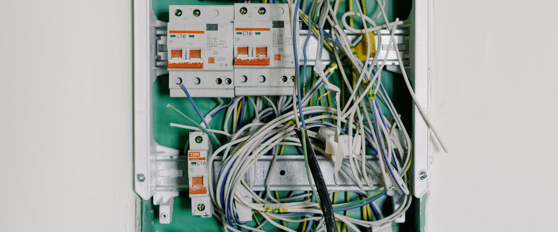 Opened electrical switchbox — qualified electrician carrying out an EICR inspection at a rental property